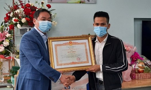 Phó Chủ tịch thường trực UBND thành phố Hà Nội Lê Hồng Sơn trao tặng bằng khen của Thủ tướng cho anh Nguyễn Ngọc Mạnh. Ảnh: M. Thanh