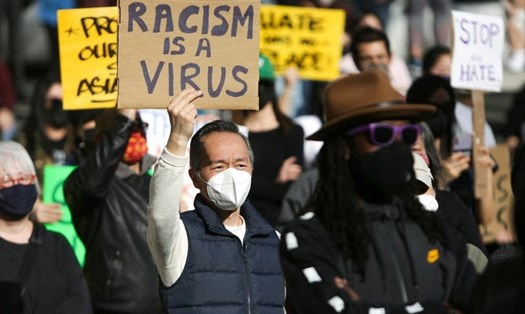 Người biểu tình mang các biểu ngữ “Chấm dứt thù hận“, “Phân biệt chủng tộc là virus“... Ảnh: AFP