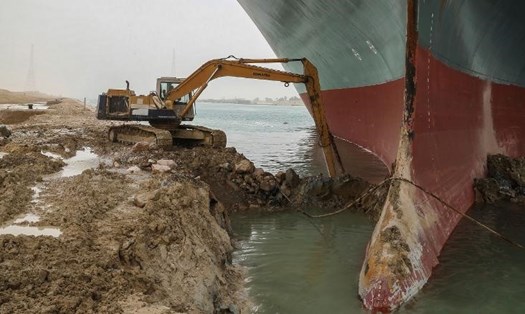 Dọn cát ở phần trước của tàu Ever Given mắc kẹt ở kênh đào Suez. Ảnh: AP.