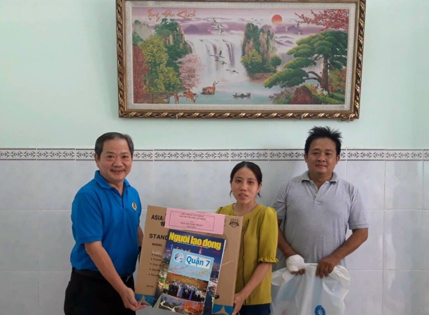 Ông Nguyễn Phi Hổ (trái), Phó Trưởng Ban Chính sách - Pháp luật LĐLĐ TPHCM trao quà cho gia đình chị Xuân. Ảnh LĐLĐ Quận 7.