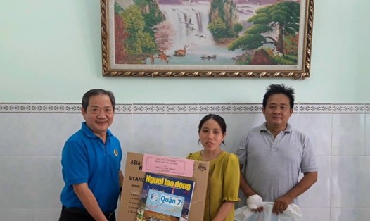 Ông Nguyễn Phi Hổ (trái), Phó Trưởng Ban Chính sách - Pháp luật LĐLĐ TPHCM trao quà cho gia đình chị Xuân. Ảnh LĐLĐ Quận 7.