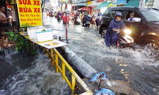 Nước chảy cuồn cuộn xuống con suối gần đường ray cắt ngang đường Tô Ngọc Vân (Thành phố Thủ Đức).  Ảnh: Minh Quân