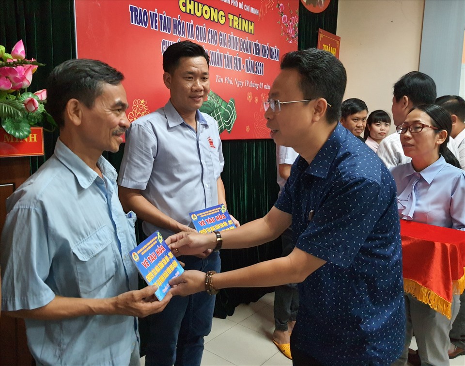 Ông Nguyễn Thành Đô - Trưởng Ban Chính sách-Pháp luật LĐLĐ TPHCM - tặng vé tàu hỏa của chương trình "Chuyến tàu mùa xuân" cho công nhân lao động ở quận Tân Phú về quê đón Tết. Ảnh: Nam Dương