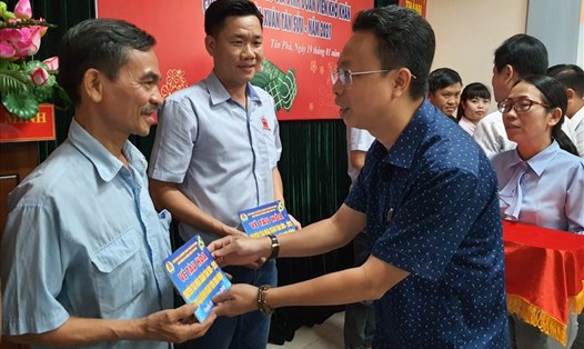 Ông Nguyễn Thành Đô - Trưởng Ban Chính sách-Pháp luật LĐLĐ TPHCM - tặng vé tàu hỏa của chương trình "Chuyến tàu mùa xuân" cho công nhân lao động ở quận Tân Phú về quê đón Tết. Ảnh: Nam Dương