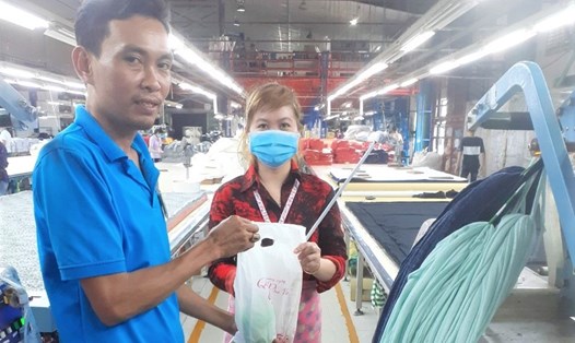 Cán bộ công đoàn cơ sở Công ty May mặc Triple Việt Nam tặng quà cho lao động nữ. Ảnh: Đức Long