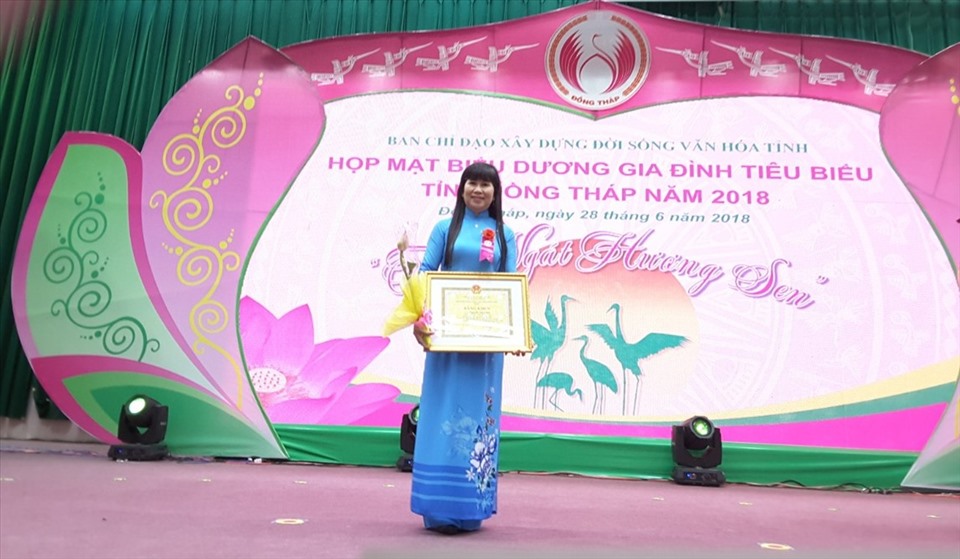 Chị Nguyễn Thị Thảo nhận Bằng khen có thành tích xuất sắc trong thực hiện Phong trào thi đua “Toàn dân đoàn kết xây dựng đời sống văn hóa”, “Công tác gia đình và phòng chống bạo lực gia đình giai đoạn 2013 - 2017”. Ảnh: Lưu Hùng