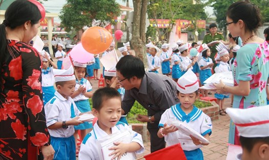 Giáo viên tỉnh Nghệ An tặng quà cho học sinh trong Lễ khai giảng năm học mới. Ảnh: Quang Đại