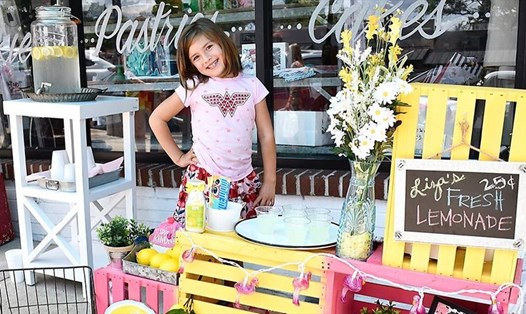 Cô bé người Mỹ Liza Scott (7 tuổi) bán nước chanh để tự quyên góp tiền phẫu thuật cho chính mình. Ảnh: Facebook