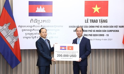 Thứ trưởng Ngoại giao Nguyễn Quốc Dũng trao tượng trưng cho Đại sứ Campuchia tại Việt Nam Chay Navuth khoản hỗ trợ 200.000 USD của Chính phủ và nhân dân Việt Nam. Ảnh: Bộ Ngoại giao.