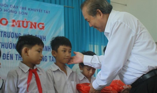 Phó Thủ tướng Thường trực Trương Hòa Bình tặng quà cho học sinh có hoàn cảnh khó khăn ở Quảng Ngãi. Ảnh: Huyền Trang