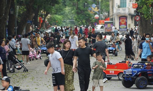 Một số người dân xuống phố đi bộ hồ Gươm "quên" đeo khẩu trang. (Ảnh chụp ngày 11.4). Ảnh: Tùng Giang