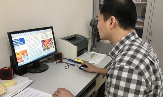 Cán bộ Liên đoàn Lao động tỉnh Thái Bình thiết kế tờ rơi tuyên truyền về công tác bầu cử. Ảnh: CTV