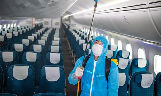 Nhân viên vệ sinh thực hiện việc phun khử khuẩn trên máy bay. Ảnh VNA