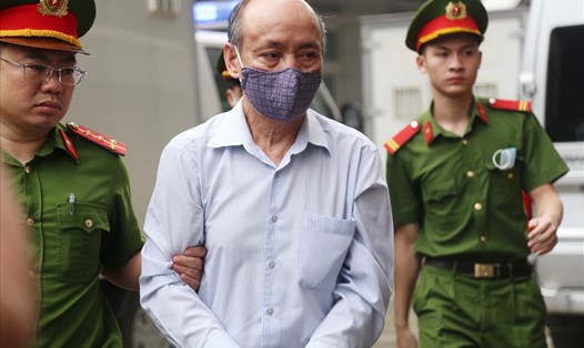 Cựu Tổng giám đốc Gang thép Thái Nguyên - Trần Trọng Mừng (áo trắng) - bị dẫn giải vào phòng xử án. Ảnh: V.Dũng