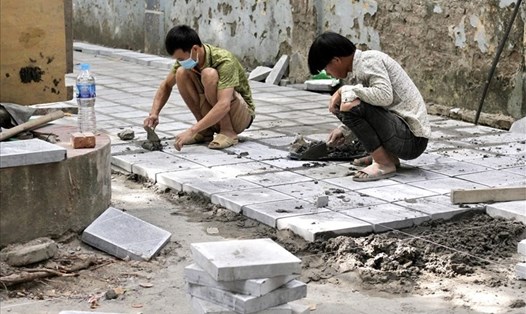 Công nhân thi công lát đá vỉa hè ở Hà Nội. Ảnh minh họa: LĐO.