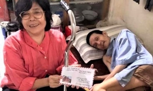 Chị Kim Anh và chồng trong lần nhận tiền do các cựu đồng nghiệp ở Xí nghiệp Toa xe Sài Gòn hỗ trợ. Ảnh: Đức Long