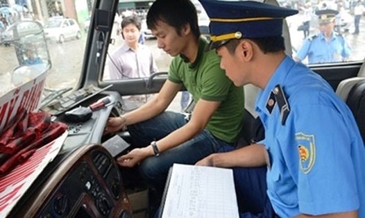 Thanh tra giao thông kiểm tra thiết bị giám sát hành trình trên một xe khách. Ảnh: GT