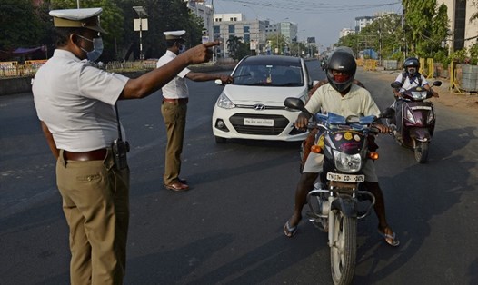 Cảnh sát kiểm tra giấy tờ tùy thân của người đi đường hôm 25.4 khi Ấn Độ thực hiện phong tỏa ngăn chặn lây lan COVID-19. Ảnh: AFP