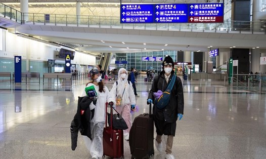 Hành khách mặc đồ bảo hộ tại một sân bay ở Hong Kong (Trung Quốc). Ảnh: AFP