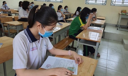 Thí sinh ở Hà Nội tìm hiểu nội dung trong phiếu đăng ký dự thi kỳ thi tốt nghiệp THPT và xét tuyển vào các trường đại học năm 2021. Ảnh: Huyên Nguyễn