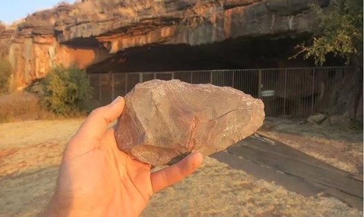Một chiếc rìu ở Wonderwerk, Nam Phi. Hậu cảnh là cửa hang. Ảnh: Nhóm khảo cổ khai quật hang Wonderwerk.