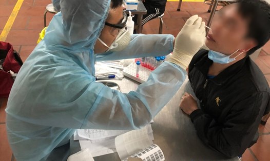Cán bộ y tế tỉnh Hưng Yên lấy mẫu xét nghiệm virus SARS-COV-2 cho người lao động, thời điểm tháng 2.2021. Ảnh: Hà Anh