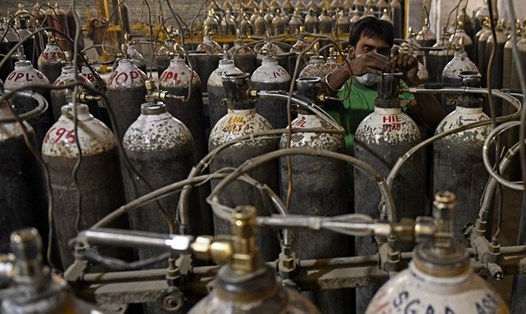 Công nhân đang phân loại bình ôxy dùng cho bệnh nhân COVID-19 tại một cơ sở ở ngoại ô Amritsar, Ấn Độ. Ảnh: AFP.