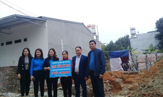 Bà Trịnh Thị Thoa, Chủ tịch Liên đoàn Lao động tỉnh Vĩnh Phúc (thứ 3 từ trái qua) trao tiền hỗ trợ cho gia đình chị Mai. Ảnh: Quốc Hương