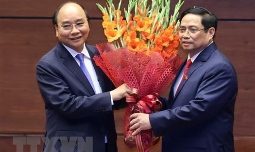 Thủ tướng Phạm Minh Chính tặng hoa Chủ tịch Nước Nguyễn Xuân Phúc. Ảnh: TTXVN