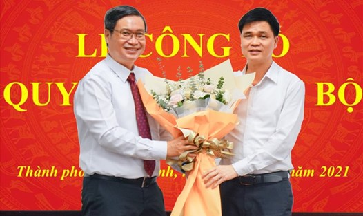Phó Chủ tịch Tổng LĐLĐ Việt Nam Ngọ Duy Hiểu (bên phải) tặng hoa chúc mừng ông Vương Đức Hoàng Quân được chỉ định làm Bí thư Đảng ủy Trường Đại học Tôn Đức Thắng. Ảnh Đức Long