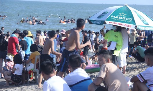 Hàng nghìn người dân vẫn tập trung tắm biển Sầm Sơn, không đeo khẩu trang. Ảnh: X.H