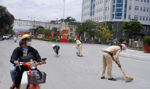 Hình ảnh 2 CSGT dọn dẹp đất đá trên đường phố Điện Biên Phủ. Ảnh cắt từ clip.