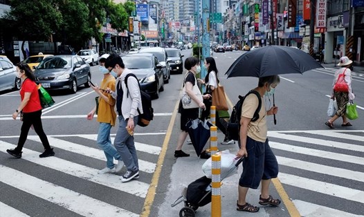 Người dân đeo khẩu trang khi di chuyển ở Tân Đài Bắc, Đài Loan (Trung Quốc) hôm 15.5 trong bối cảnh COVID-19 diễn biến đáng lo ngại. Ảnh: AFP