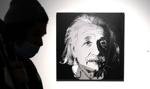 Một người đi qua bức vẽ "Albert Einstein" của Andy Warhol. Ảnh: AFP.