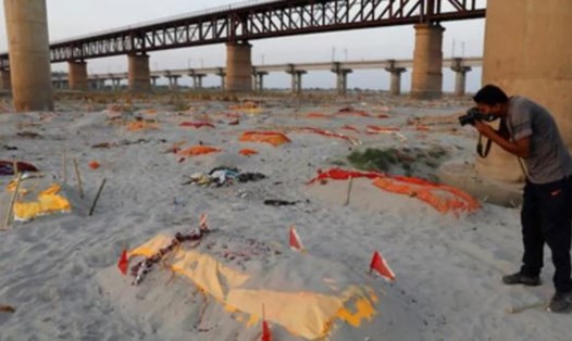 Thi thể trong các ngôi mộ nông trên cát lộ diện la liệt trên bờ sông Hằng, Ấn Độ, sau cơn mưa lớn. Ảnh: AFP