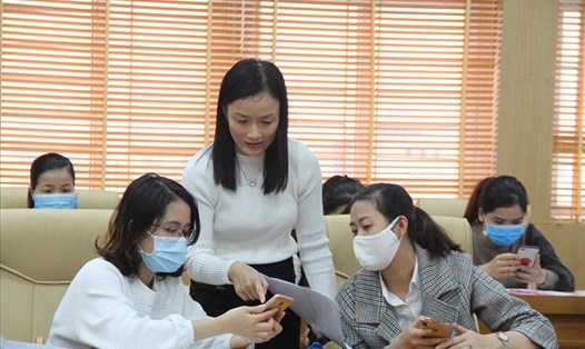 Cán bộ nghiệp vụ Bảo hiểm xã hội Thành phố Đà Nẵng hướng dẫn người lao động cài đặt, đăng ký sử dụng ứng dụng VssID. Ảnh: Kim Oanh
