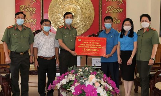 Đại diện lãnh đạo Liên đoàn Lao động tỉnh Hà Nam trao tặng 15 triệu đồng tiền mặt cho đại diện lãnh đạo Công an tỉnh Hà Nam. Ảnh: CA Hà Nam.