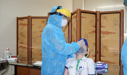 Nhân viên y tế thực hiện lấy mẫu xét nghiệm SARS-CoV-2 cho người lao động tại Công ty Nidec Tosok. Ảnh: HCDC.
