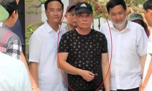 Nghi phạm bắn chết 2 người với một điếu thuốc trên tay -thay vì chiếc còng số 8 - được chính Giám đốc Công an tỉnh Nghệ An dẫn giải. Ảnh: VTC