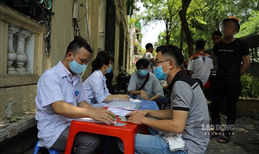 Lực lượng chức năng quận Hoàn Kiếm xử phạt người không đeo khẩu trang. Ảnh: Tô Thế