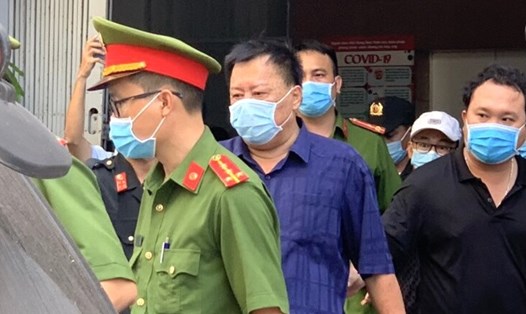 Cơ quan chức năng bắt tạm giam ông Võ Tấn Thái (áo xanh) và đưa đi từ nhà riêng sau khi hoàn thành khám xét. Ảnh: Hoàng Anh