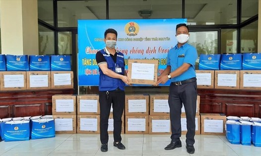 Lãnh đạo Công đoàn các khu công nghiệp tỉnh Thái Nguyên (bên phải) tặng nước rửa tay diệt khuẩn và khẩu trang cho đại diện đoàn viên. Ảnh: CĐTN