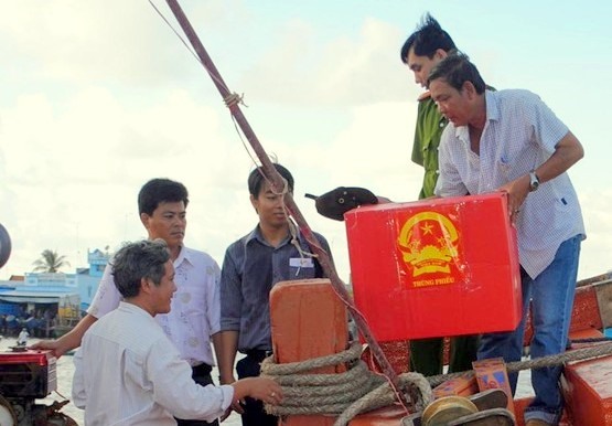Lực  lượng làm nhiệm vụ bầu cử chuyển thùng phiếu, hồ sơ từ tàu lên đảo Hòn Khoai chuẩn bị công tác bầu cử sớm. Ảnh: Nhật Hồ