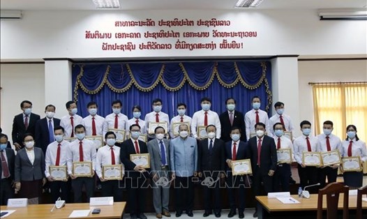 Phó Thủ tướng Lào Kikeo Khaykhamphithoune (giữa) cùng các quan chức chụp ảnh lưu niệm với Đoàn chuyên gia y tế Việt Nam. Ảnh: TTXVN