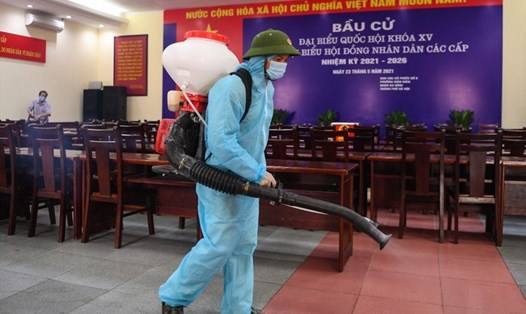 Phun khử khuẩn phòng ngừa COVID-19 tại một điểm bỏ phiếu ở Hà Nội. Nguồn: AFP