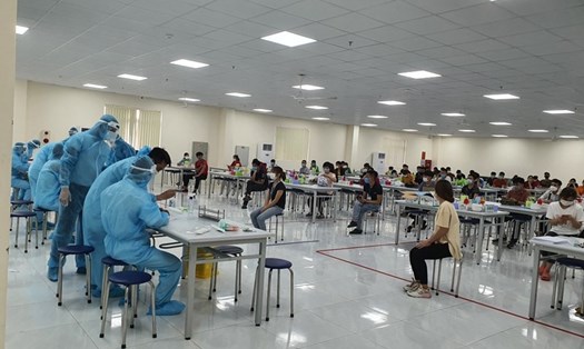 Lực lượng y tế lấy mẫu xét nghiệm COVID-19 cho công nhân tại KCN Vân Trung (Bắc Giang).