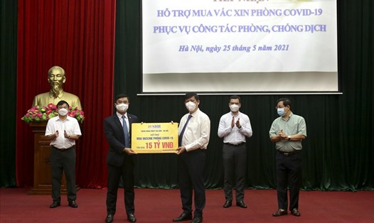 Tổng Giám đốc Nguyễn Văn Lê - đại diện SHB trao tặng Bộ Y tế 15 tỉ đồng hỗ trợ kinh phí mua vaccine phòng COVID-19. Ảnh: SHB