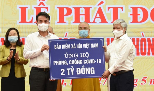 Tổng Giám đốc BHXH Việt Nam Nguyễn Thế Mạnh (bên trái) trao 2 tỉ đồng ủng hộ phòng, chống dịch COVID-19 tới Ủy ban Trung ương Mặt trận tổ quốc Việt Nam. Ảnh: BHXH