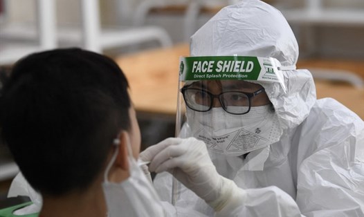 Nhân viên y tế lấy mẫu xét nghiệm COVID-19 tại một địa điểm ở Hà Nội. Nguồn: AFP
