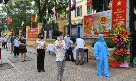 Người dân Hà Nội thực hiện giãn cách xã hội để phòng ngừa COVID-19 khi đi bầu cử. Ảnh: AFP